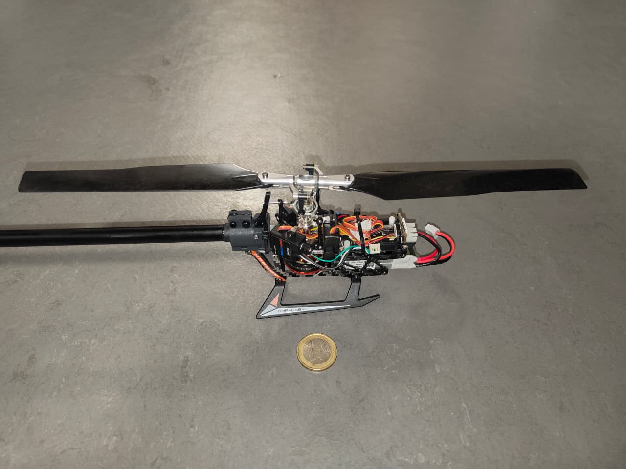 Close-up of the prototype's rotor head and fuselage, with a coin for scale
